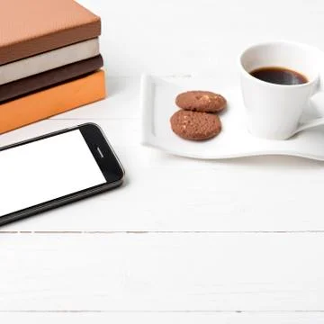 Coffe cup with cookie,phone and stack of book Foto stock