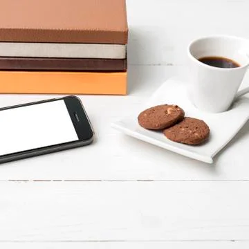 Coffe cup with cookie,phone and stack of book Stock Photos