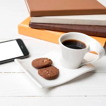 Coffe cup with cookie,phone and stack of book Foto stock