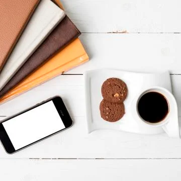 Coffe cup with cookie,phone and stack of book Foto stock