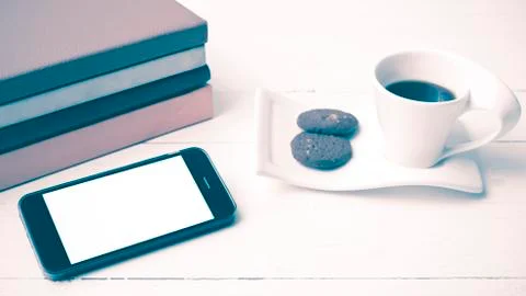Coffe cup with cookie,phone and stack of book vintage style Foto stock