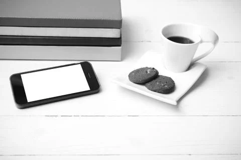 Coffe cup with cookie,phone and stack of book black and white co Stock Photos