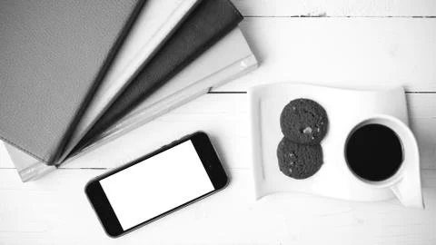 Coffe cup with cookie,phone and stack of book black and white co Foto stock