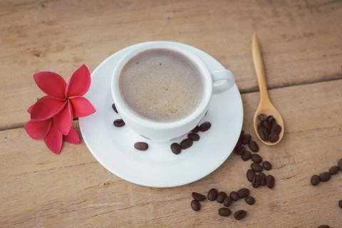 Coffee and bubble in white coffee cup and saucer with spoon on wooden backg.. Stock Photos