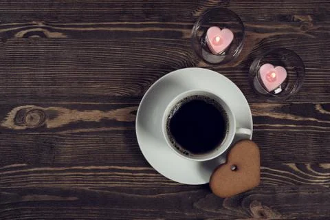 Coffee and cake in the shape of a heart on wooden planks Stock Photos