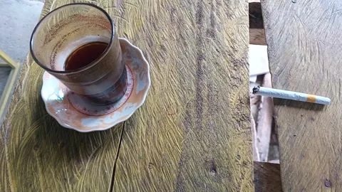 Coffee and Cigarette on Rustic Table Stock Footage 314588337