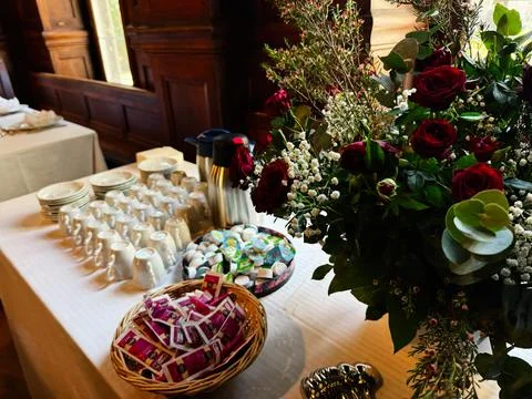 Coffee and floral buffet table with red roses and cups at an elegant recept.. Stock Photos
