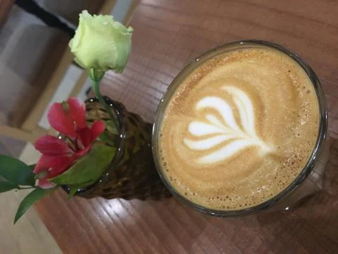 Coffee and flowers on the table Stock Photos