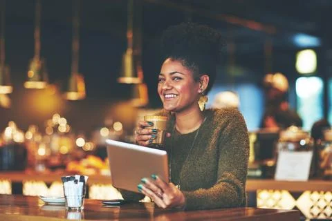 Coffee and free wifi. Thats what its all about. a young woman using a digital Stock Photos