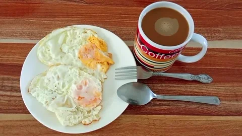 Coffee and fried eggs on the table Stock Footage 323191316