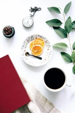 Coffee and red book on the table with dried oranges and old pocket watch Stock Photos