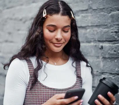 Coffee and technology go hand in hand. an attractive teenage girl standing alone Stock Photos