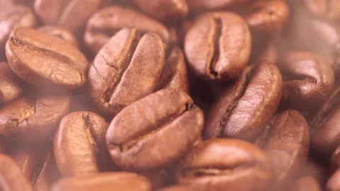 Coffee background. close up of roasted coffee beans with smoke rising and zoom Stock Footage 256145117
