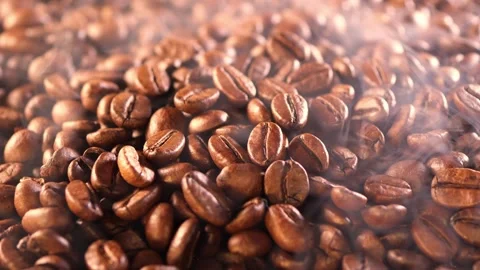 Coffee background. close up of roasted coffee beans with smoke rising and zoom Stock Footage 256145141