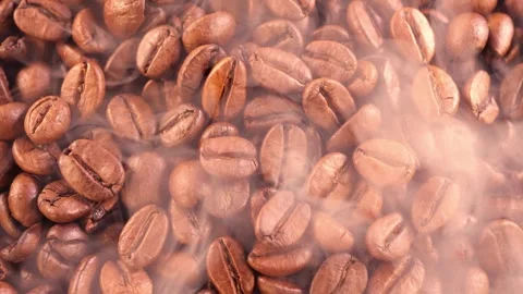 Coffee background. close up of roasted coffee beans with smoke rising and zoom Stock Footage 256497464