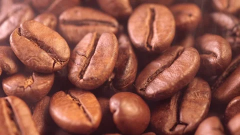 Coffee background. close up of roasted coffee beans with smoke rising and zoom Stock Footage 257310332