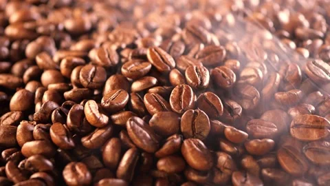 Coffee background. close up of roasted coffee beans with smoke rising and zoom Stock Footage 257310347