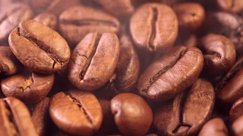 Coffee background. close up of roasted coffee beans with smoke rising and zoom Stock Footage 276742423