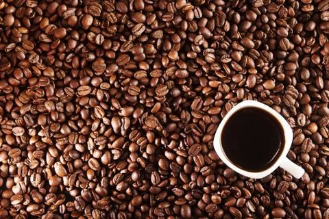Coffee background. Coffee beans and cup of coffee over table. Stock Photos