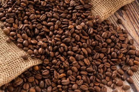 Coffee background, coffee beans on burlap and wooden table Stock Photos