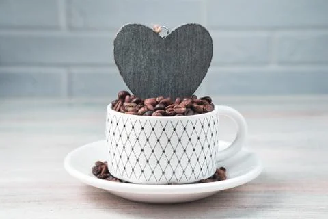 Coffee background with coffee beans in a Cup and candles on a light cozy Stock Photos