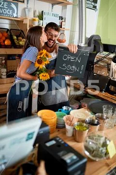 Coffee bar is open - man and woman owner with open sign.. Stock Photos