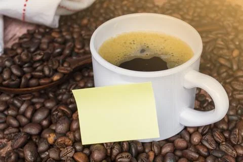 Coffee bean and note stick on a cup of coffee. Stock Photos