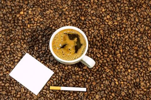 Coffee bean background with cup of fresh hot coffee and cigar with space fo.. Stock Photos