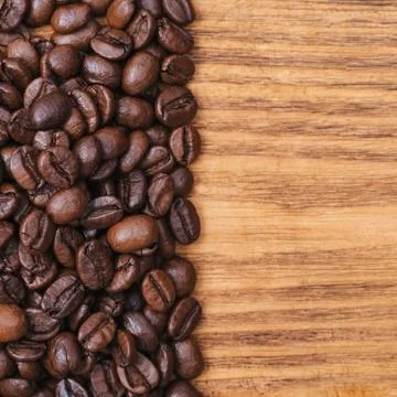 Coffee bean. The background of roasted coffee beans is brown on wooden boards Stock Photos