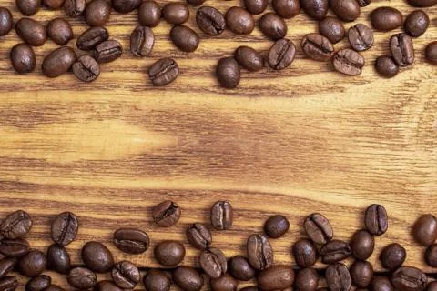 Coffee bean. The background of roasted coffee beans is brown on wooden boards Stock Photos