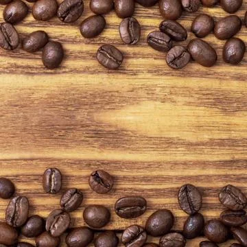 Coffee bean. The background of roasted coffee beans is brown on wooden boards Stock Photos