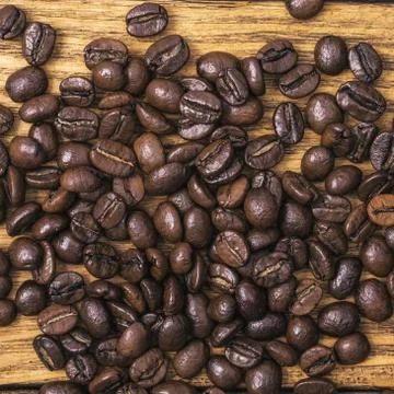 Coffee bean. The background of roasted coffee beans is brown on wooden boards Stock Photos