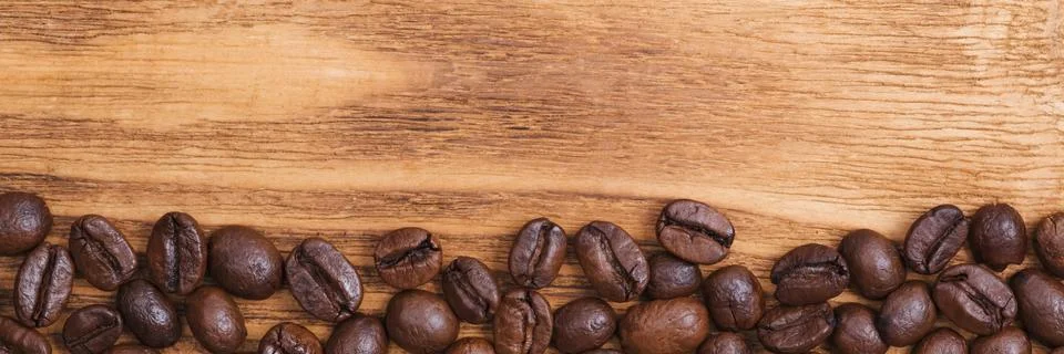Coffee bean. The background of roasted coffee beans is brown on wooden boards Stock Photos