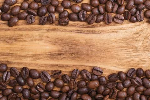 Coffee bean. The background of roasted coffee beans is brown on wooden boards Stock Photos