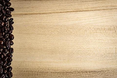 Coffee bean edged on the light brown wood grain background Stock Photos