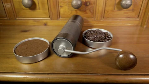 A coffee bean grinder on a pine cabinet, between ground powder and whole beans. Vídeos de archivo 295776336