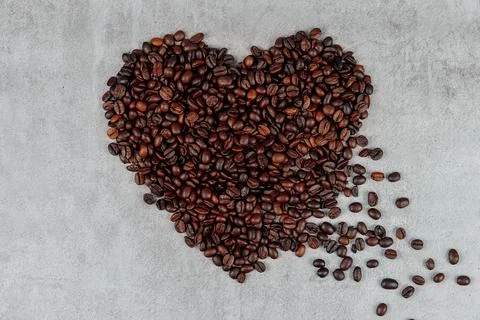 Coffee bean heart shape on gray background Stock Photos