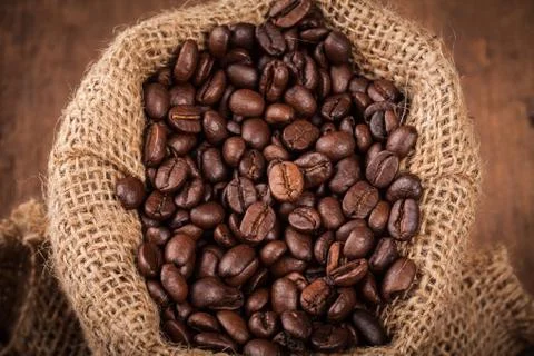 Coffee bean in sack on the wood table Stock Photos