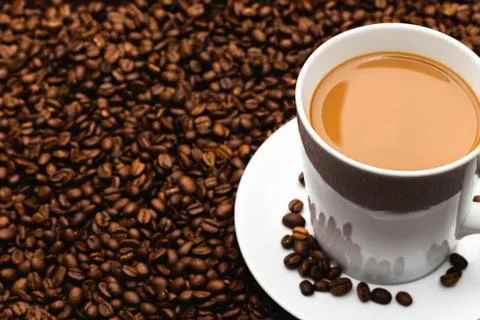 Coffee Bean Textured Background Mug and Saucer Set on Coffee Beans Stock Photos