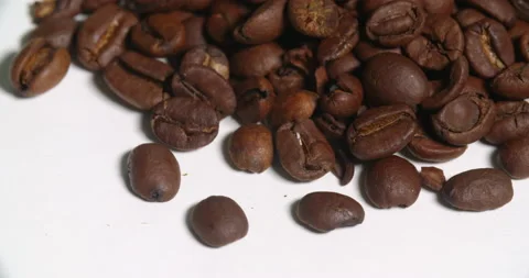 Coffee Beans Above Pile Close Up Bottom Edge on White Spins Stock Footage 64974528