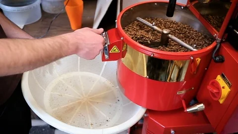 Coffee beans after roasting falling into a white basket Stock Footage 75827201