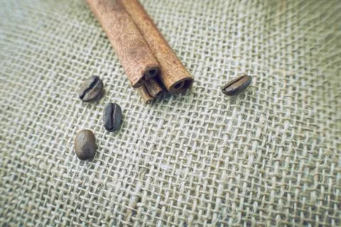 Coffee beans and cinnamon on a sacking background. Stock Photos