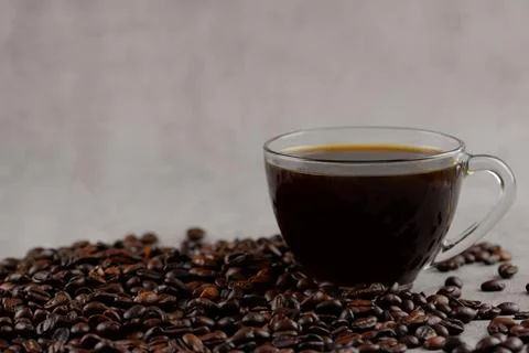Coffee beans and coffee in a cup on a gray background Stock Photos