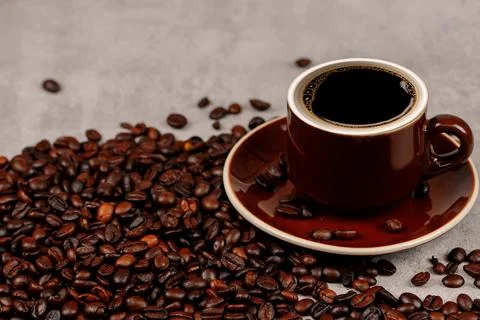 Coffee beans and coffee in a cup on a gray background Stock Photos