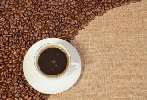 Coffee beans and a cup on sacking Stock Photos