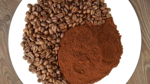Coffee beans and ground coffee rotating on white plate. Stock Footage 325174109