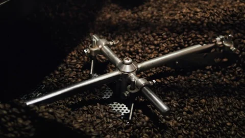 Coffee beans are being mixed by a metal wheel. Stock Footage 108064615