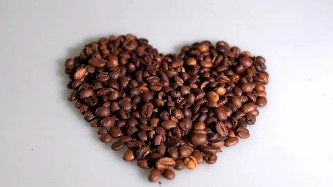 Coffee beans are collected in the shape of a heart on a white background Stock Footage 105751734