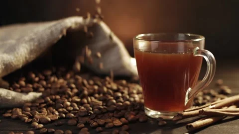 Coffee beans are falling in slow motion from the top onto a wooden table Stock Footage 146869352