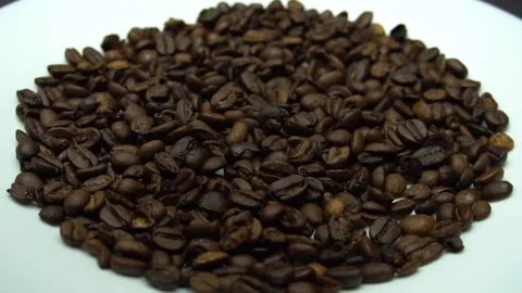 Coffee beans are falling on the white plate. Slow motion Stock Footage 86214457